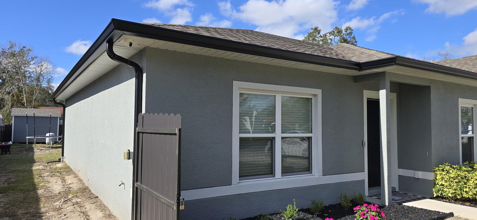 Single-story home with dark gutters and downspouts along the roofline